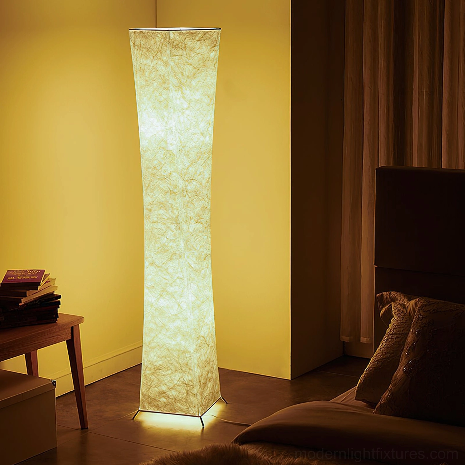 Saura modern floor lamp glowing in cozy bedroom corner beside side table with books and warm decor