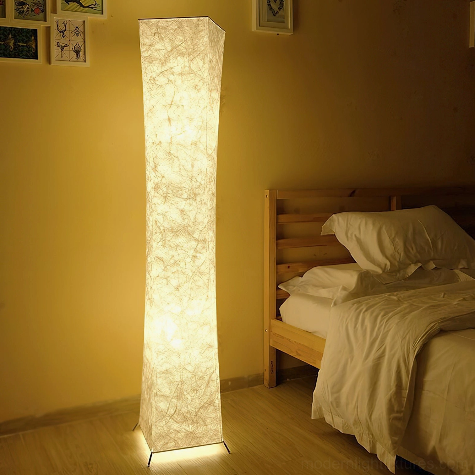Lit Saura fabric floor lamp with warm ambient light beside wooden bed in bedroom interior at night