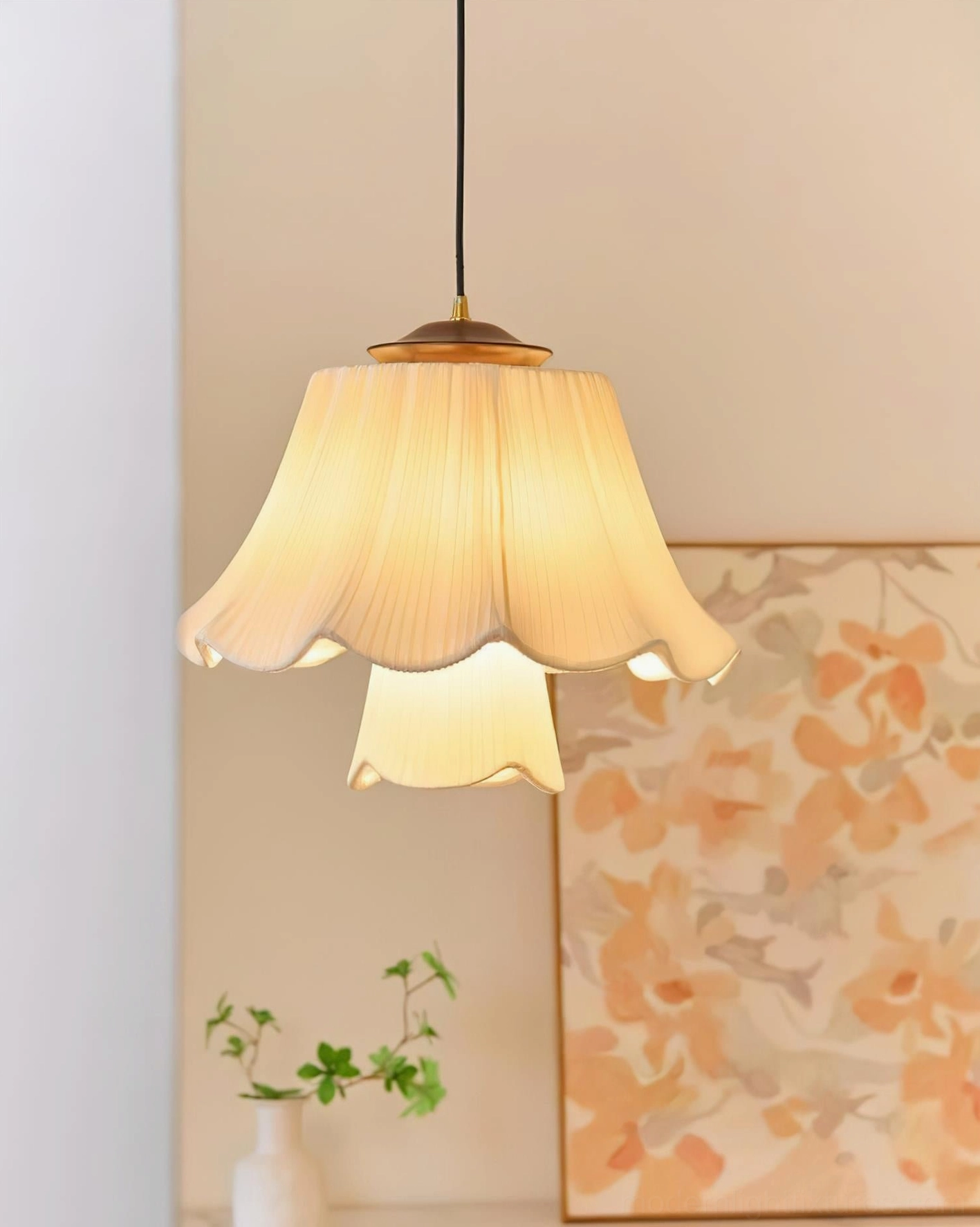 Savena single-tier pleated pendant lamp with beige ruffled fabric shade and brass metal top in modern interior setting