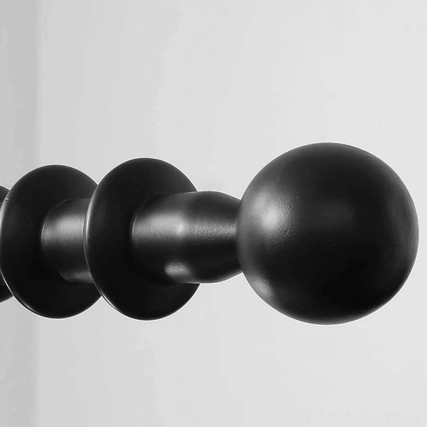 Savoy linear chandelier black metal frame component close-up with matte finish spool and ball shaped decorative details