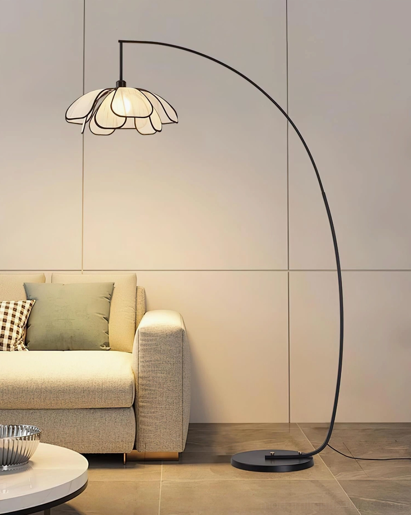 Black metal Savoy floor lamp positioned next to beige sofa and side table in modern contemporary living space