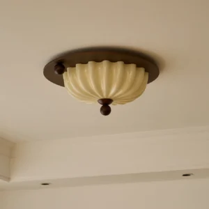 Vintage scallop ceiling lamp installed on residential ceiling with crown molding, warm light illumination