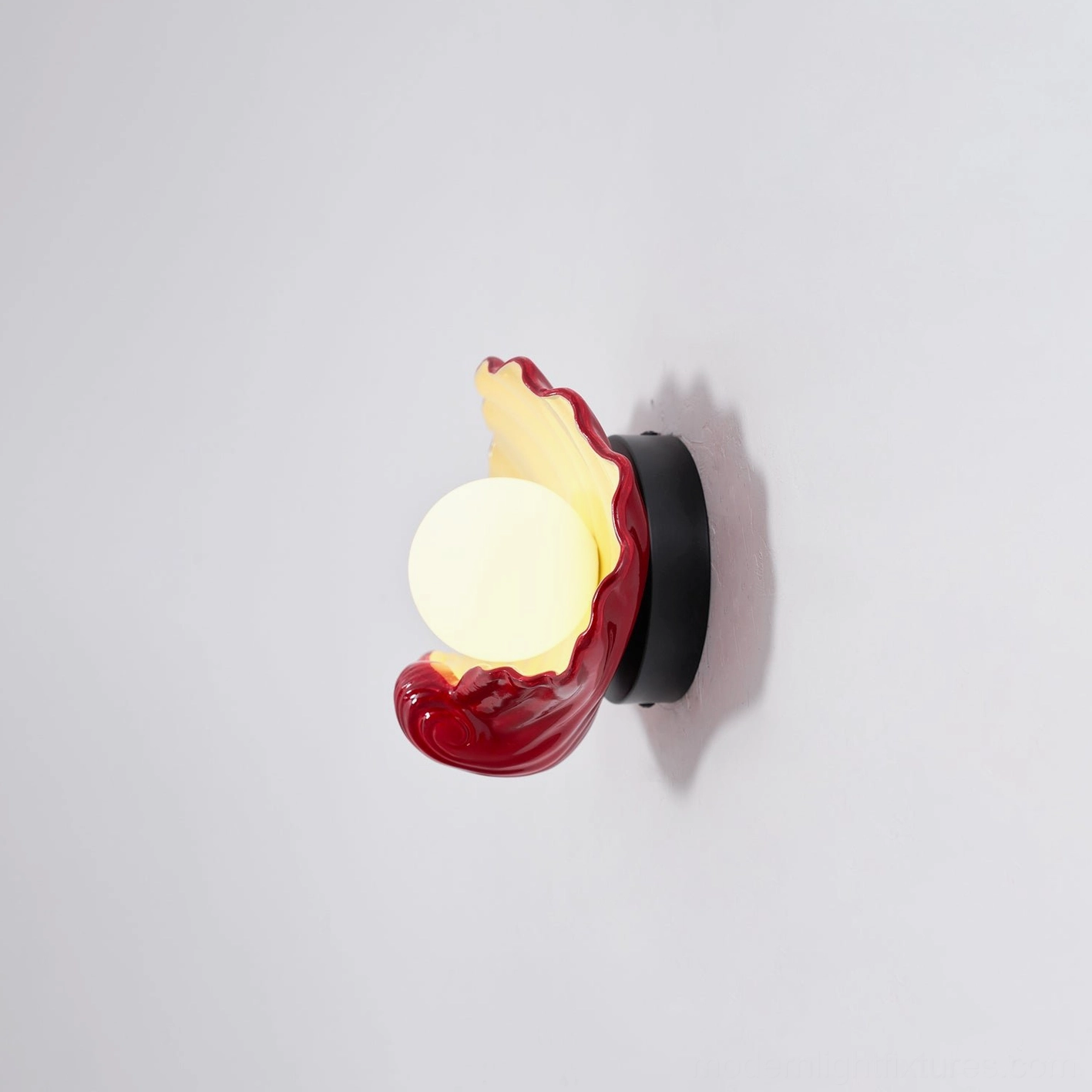Scallop shell wall lamp warm light in cozy interior, cream ceramic finish, intimate bedroom or bathroom fixture