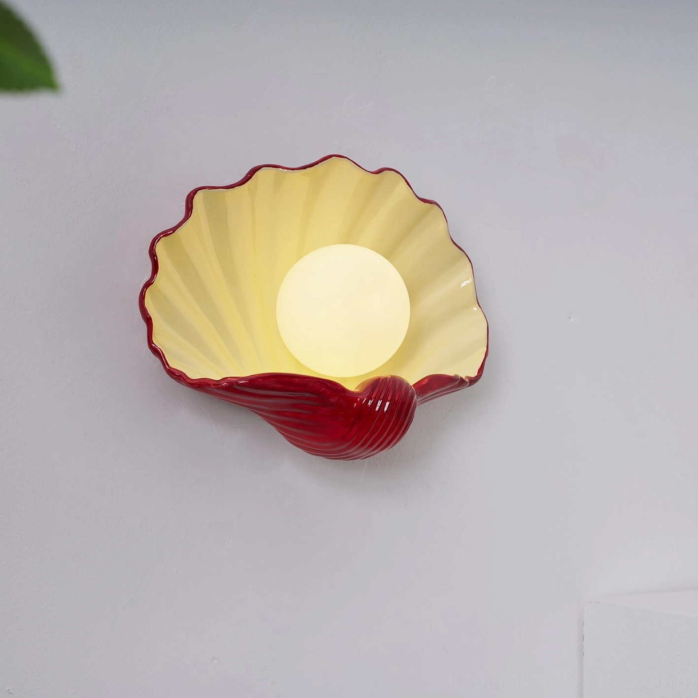 Scallop shell wall sconce warm ambient lighting, cream ceramic sculptural form, bedroom or hallway fixture