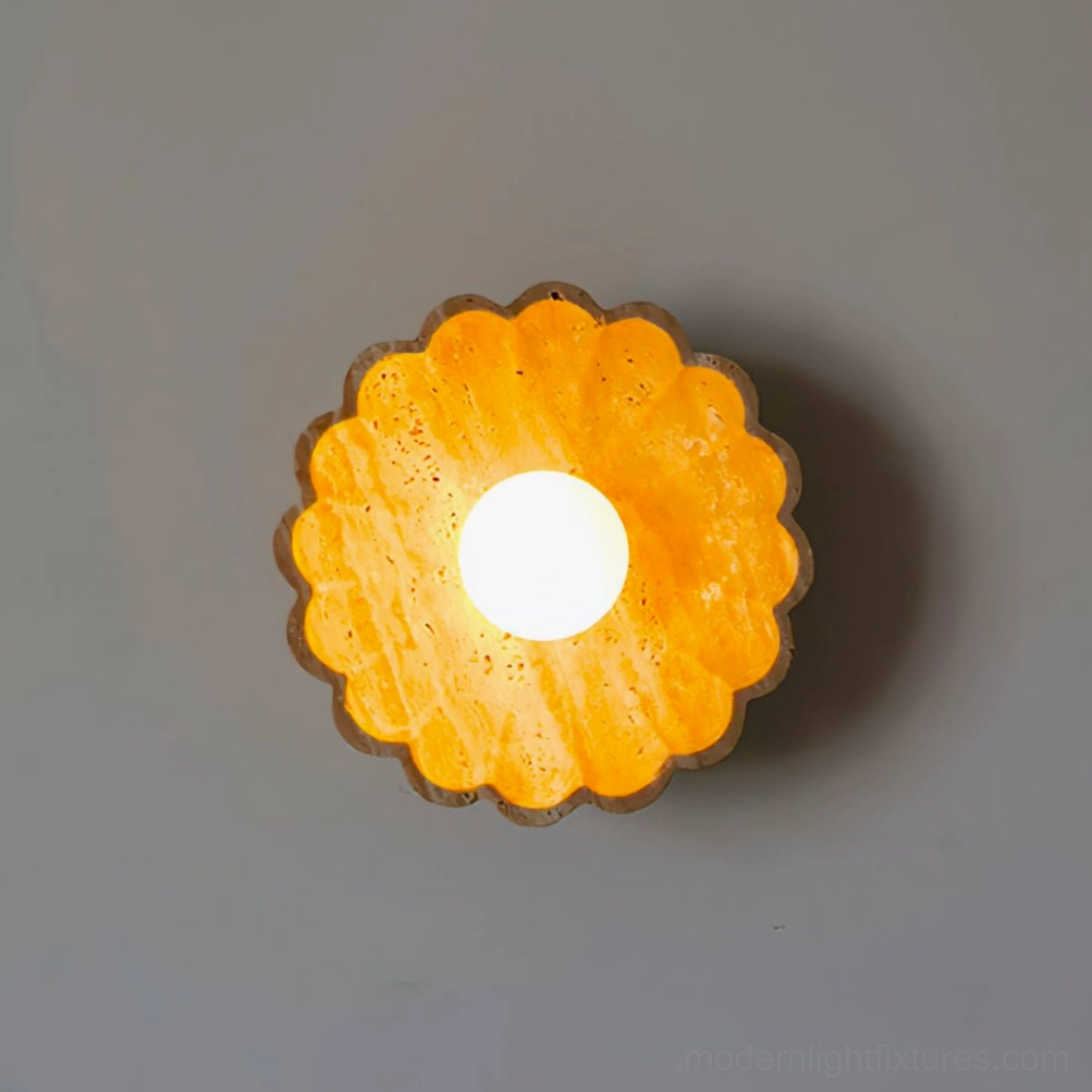 Lit scallop wall sconce emitting warm amber ambient glow on gray studio background