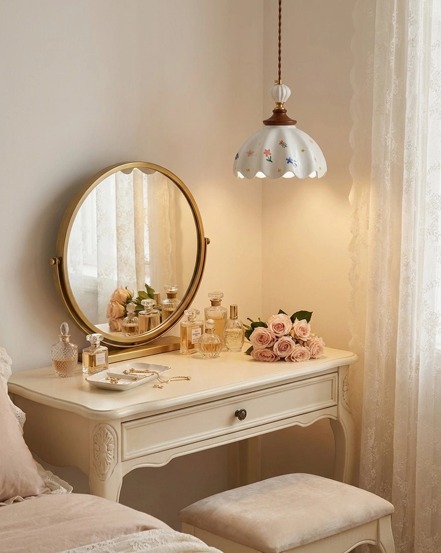 Scalloped ceramic pendant above luxury bedroom vanity with white furniture, gold-rimmed round mirror, botanical styling and decorative accessories