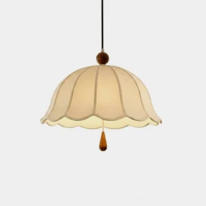 Scalloped cotton-linen pendant light with solid wood finial displayed in studio, front overhead view showing ribbed dome shade and warm cottage aesthetic
