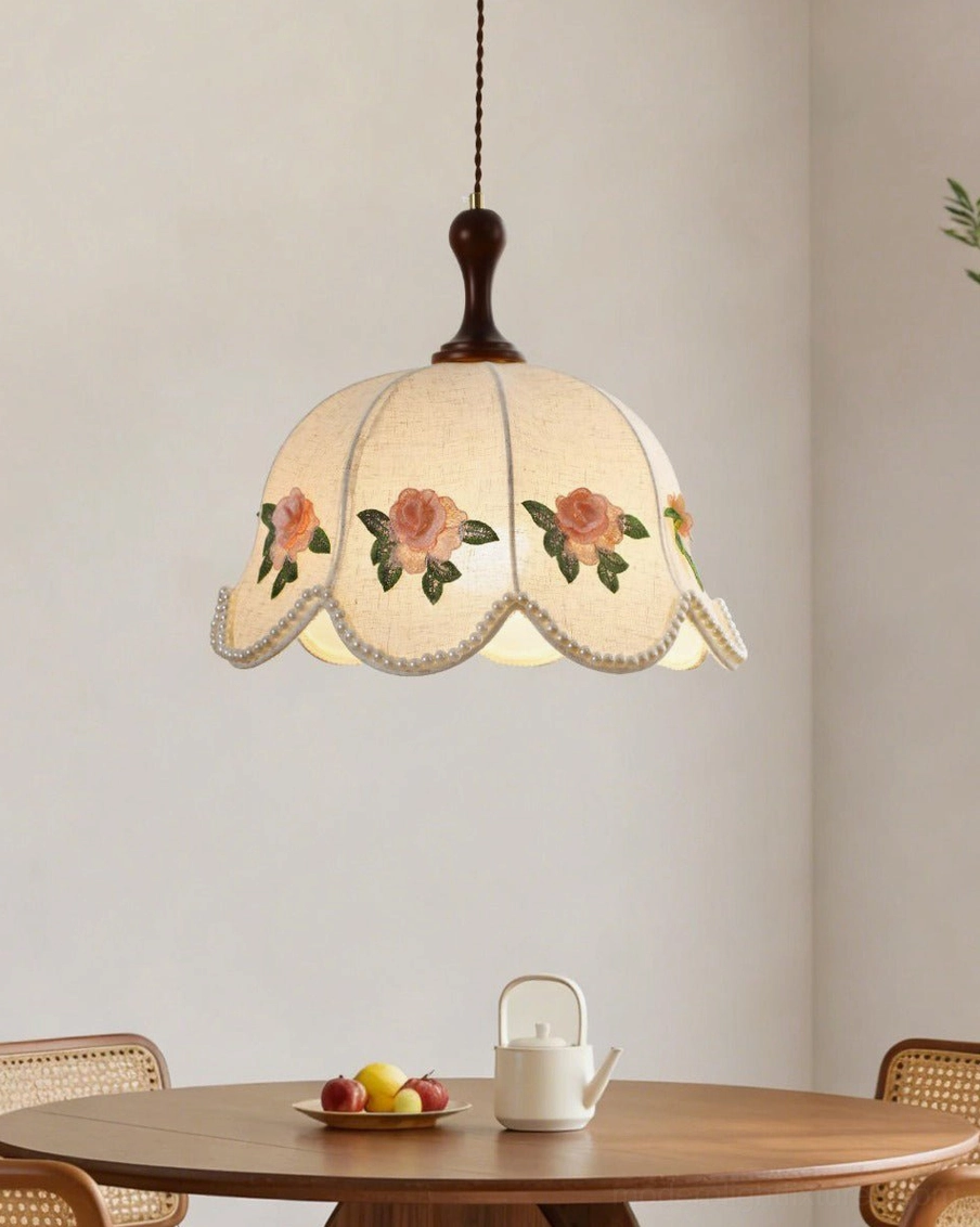 Scalloped fabric pendant light with hand-embroidered rose appliqués, low angle view in casual dining space