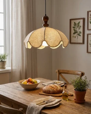 Fabric pendant light with hand-stitched scalloped shade hanging over wooden dining table warm ambient lighting