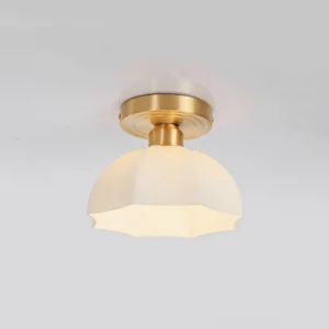 Three-quarter angle close-up of scalloped glass semi-flush ceiling fixture featuring brass canopy and milky frosted shade