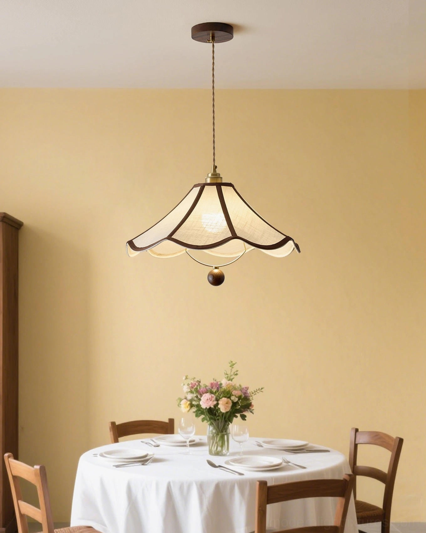 Illuminated scalloped vintage pendant lamp with brass hardware on yellow dining room wall