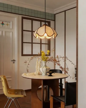 Scalloped fabric pendant light hanging above round wooden dining table in warm residential dining nook - vintage cottage pendant lighting