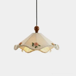 Scalloped fabric pendant light with beaded hem and embroidered roses, studio front view on white background
