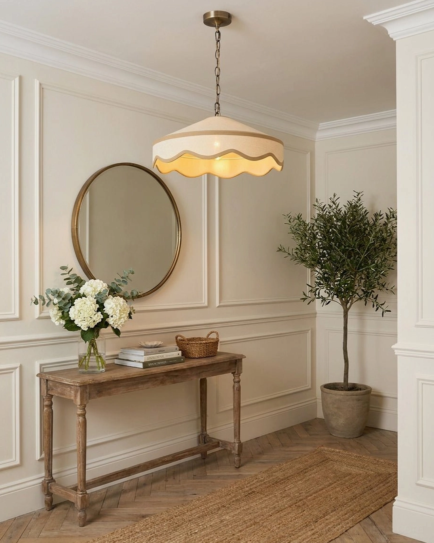 Cream scalloped pendant shade in traditional entryway with console table and clean neutral cottage styling