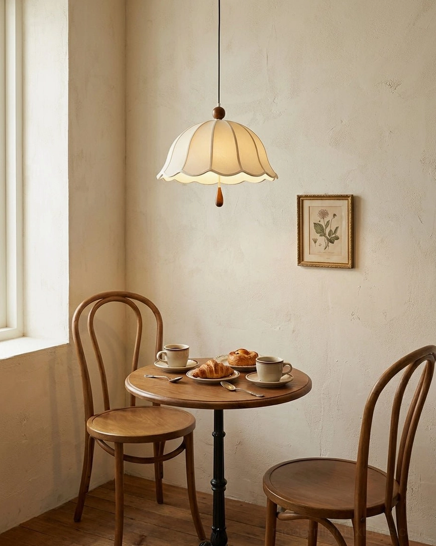 Scalloped fabric pendant hanging in intimate bistro-style dining area with vintage cafe aesthetic and warm interior styling