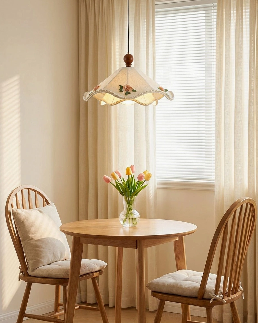 Scalloped fabric pendant light beside window in double dining nook with cozy warm cottage decor