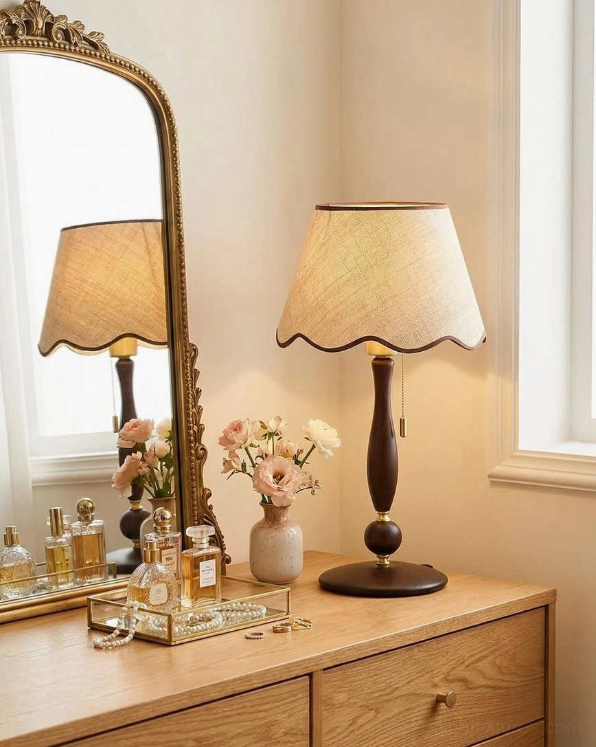 Scalloped fabric table lamp shade detail showing cream linen color walnut-brown trim and delicate hand-applied wavy hem craftsmanship with fabric texture