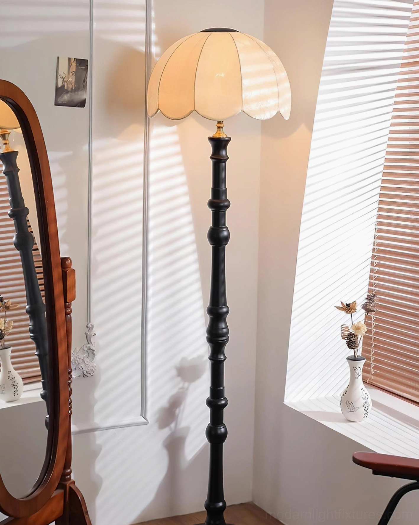 Scalloped vintage floor lamp with black carved wooden pole and off-white scalloped fabric shade beside window blinds and mirror