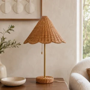 Scalora woven rattan table lamp with scalloped shade and brass stem, three-quarter angle view