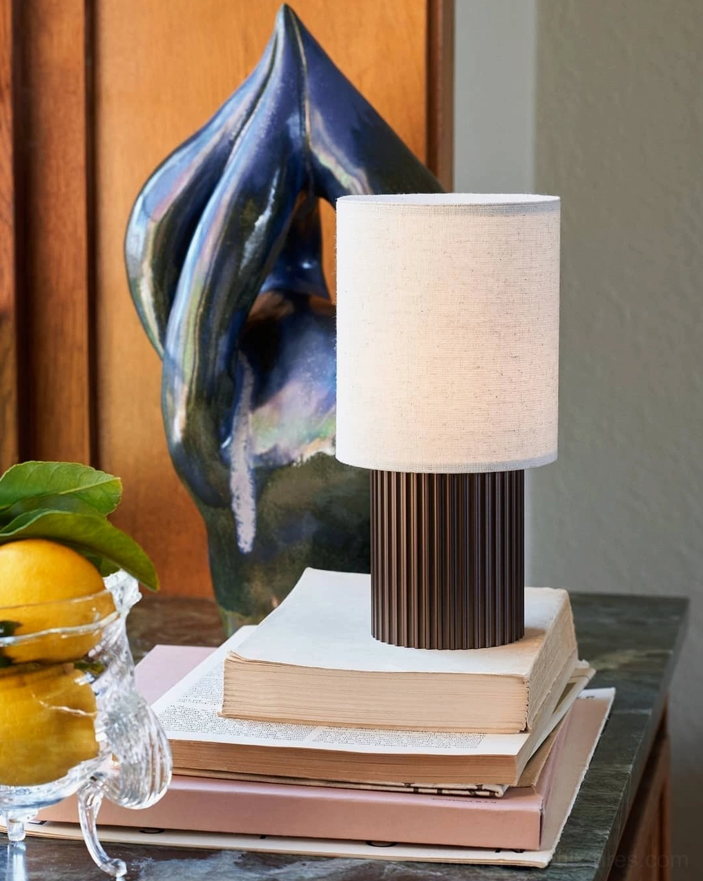 Contemporary table lamp with natural fabric shade and fluted metal base, professional studio photography showcasing Scandinavian minimalist design