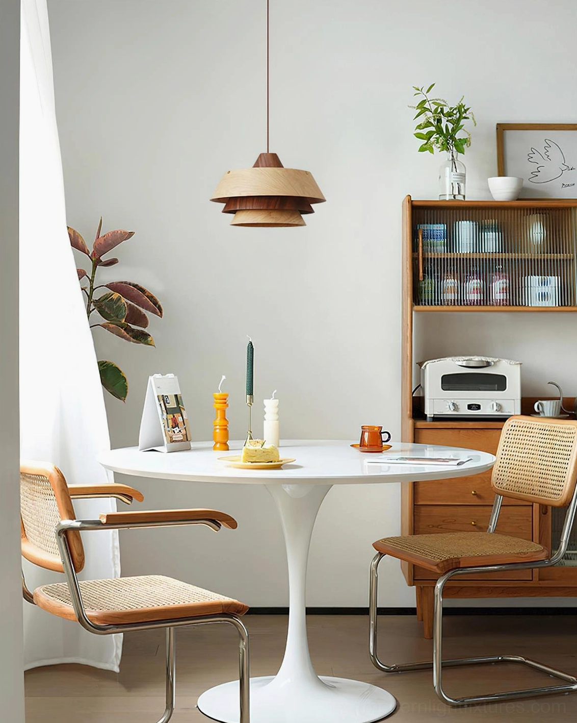 Modern tiered pendant lamp suspended above white tulip dining table in Scandinavian Nordic room design