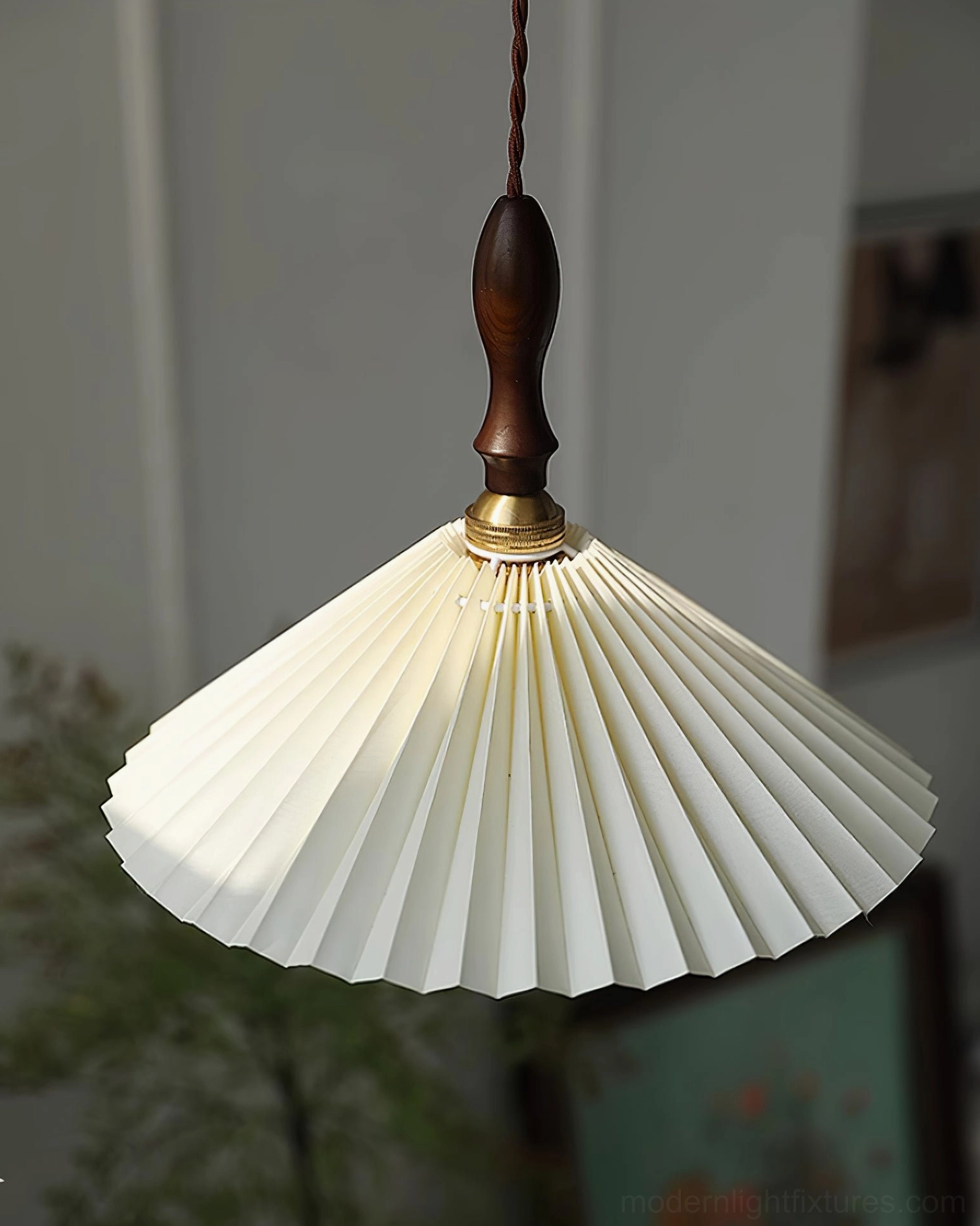 Pleated fabric pendant light with brass hardware installed in Scandinavian interior design space