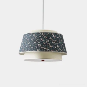 Scandinavian tiered pendant light with dark blue leaf pattern upper shade and off-white lower tier, front studio view