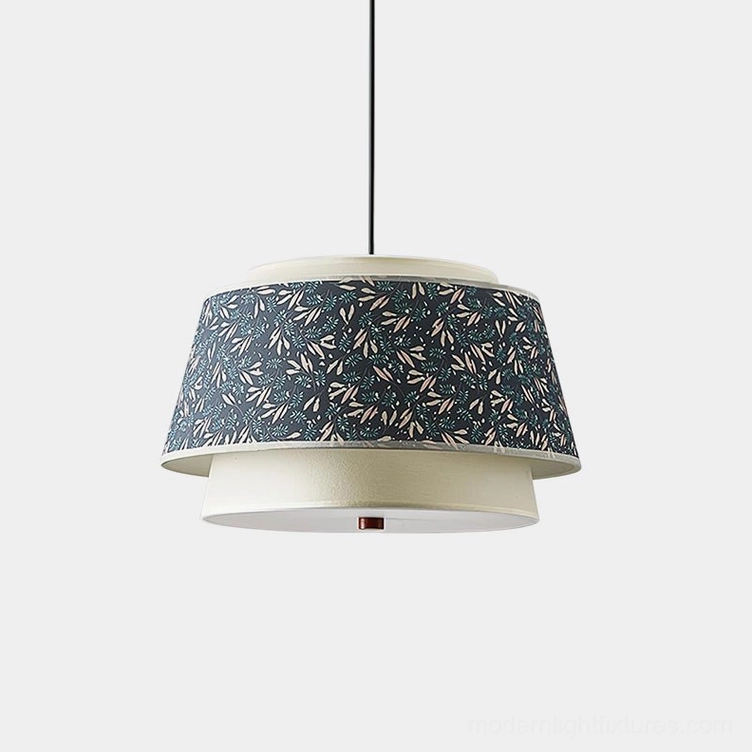 Scandinavian tiered pendant light with dark blue leaf pattern upper shade and off-white lower tier, front studio view