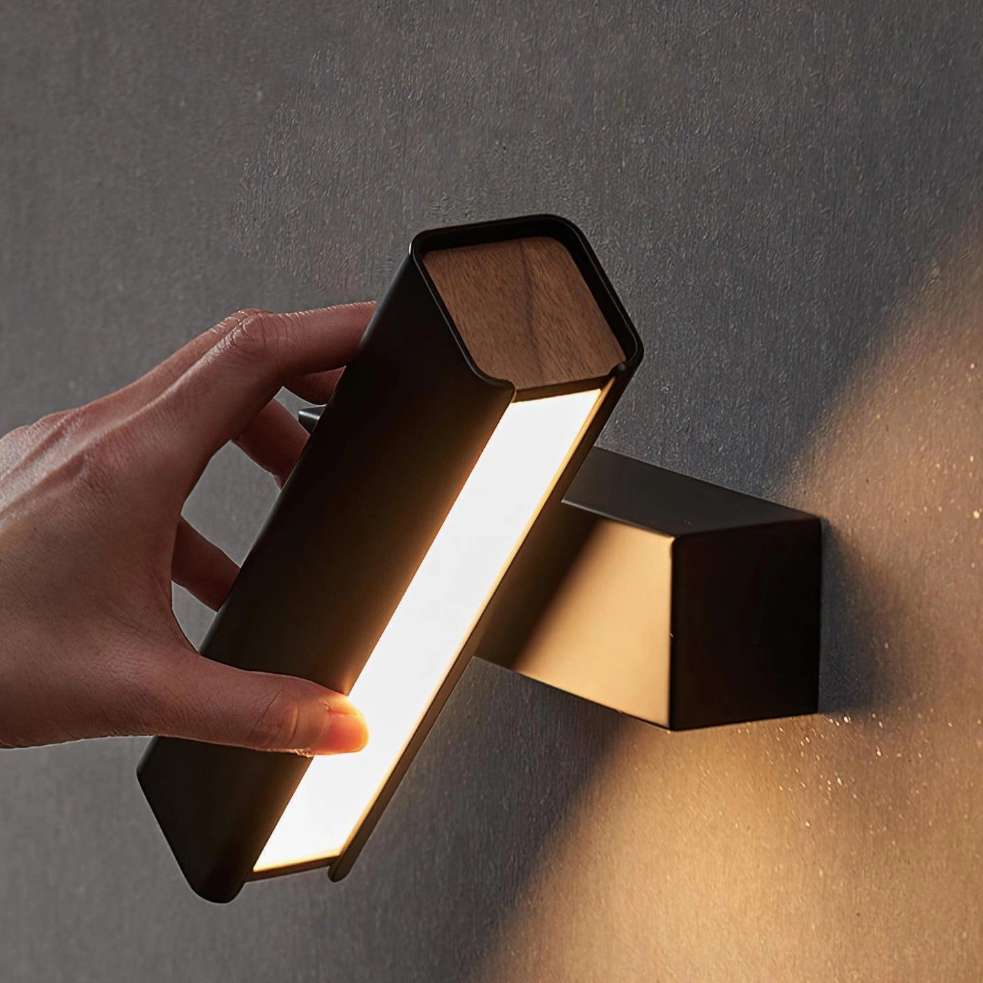 Scandinavian rotatable wall sconce with matte black base and wood trim, close-up detail showing illuminated LED