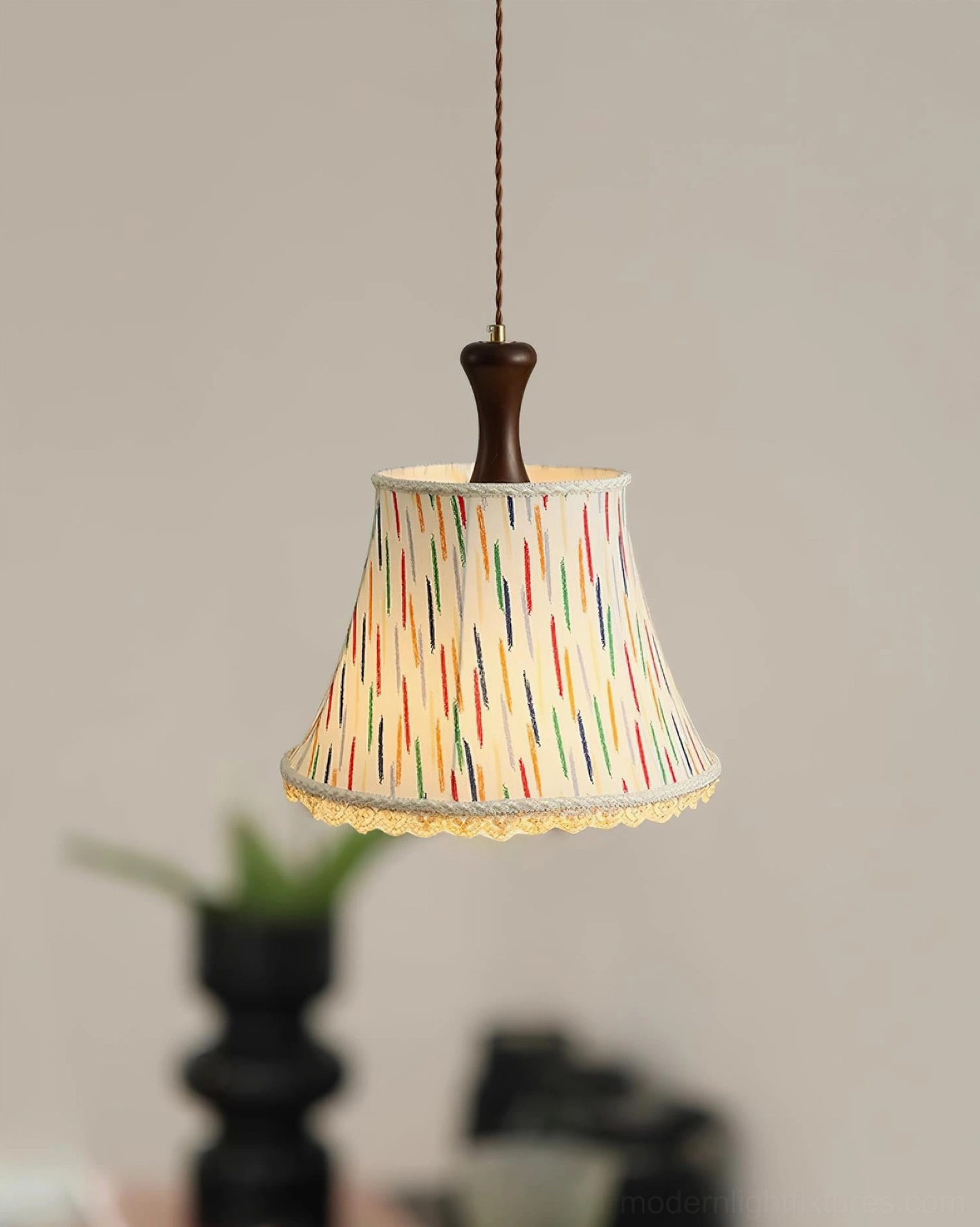 Multicolor striped fabric pendant light with wood mount illuminating modern dining and kitchen area
