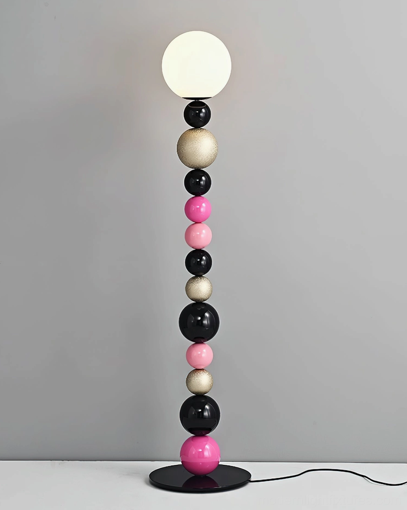 Colorful round ball floor lamp tabletop display with visible cord, gray wall backdrop, modern lamp design