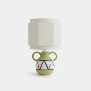 Front view of sculptural green ceramic table lamp with faceted white shade and hand-painted red navy geometric patterns on dual-handled base