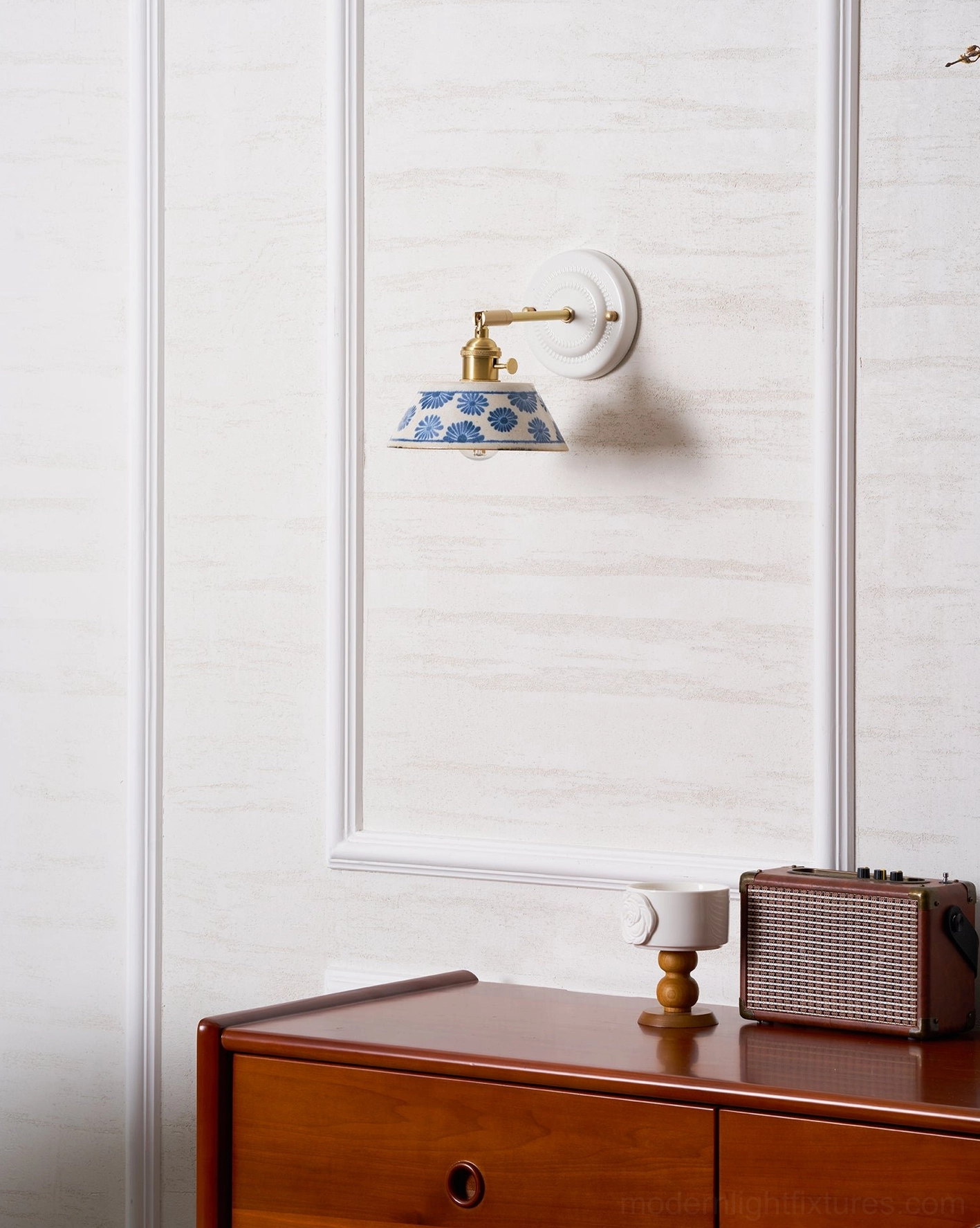 Ceramic wall sconce with sculptural form and hand-painted indigo floral patterns