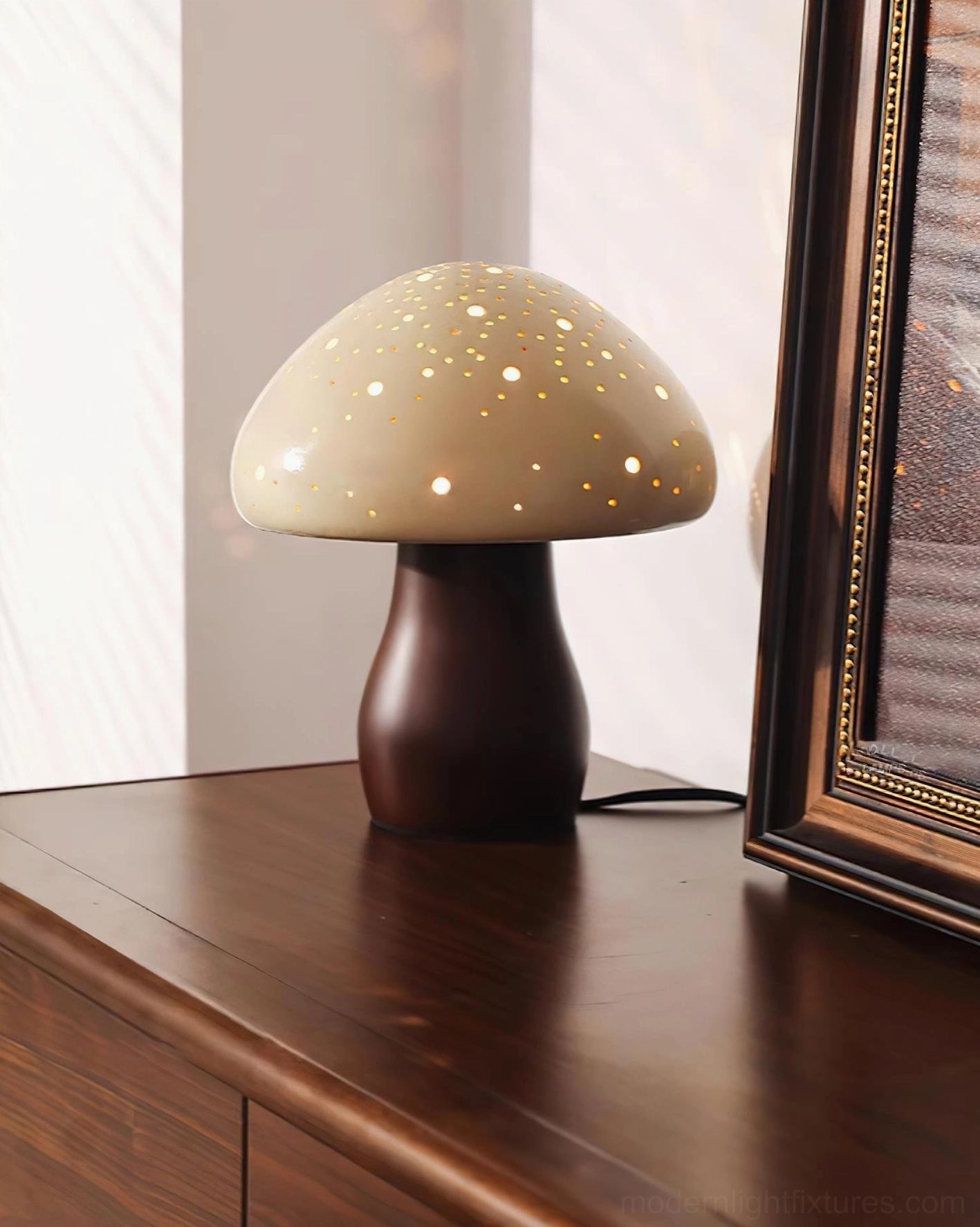 Contemporary mushroom table lamp with perforated shade on wooden dresser - light beige and brown tones