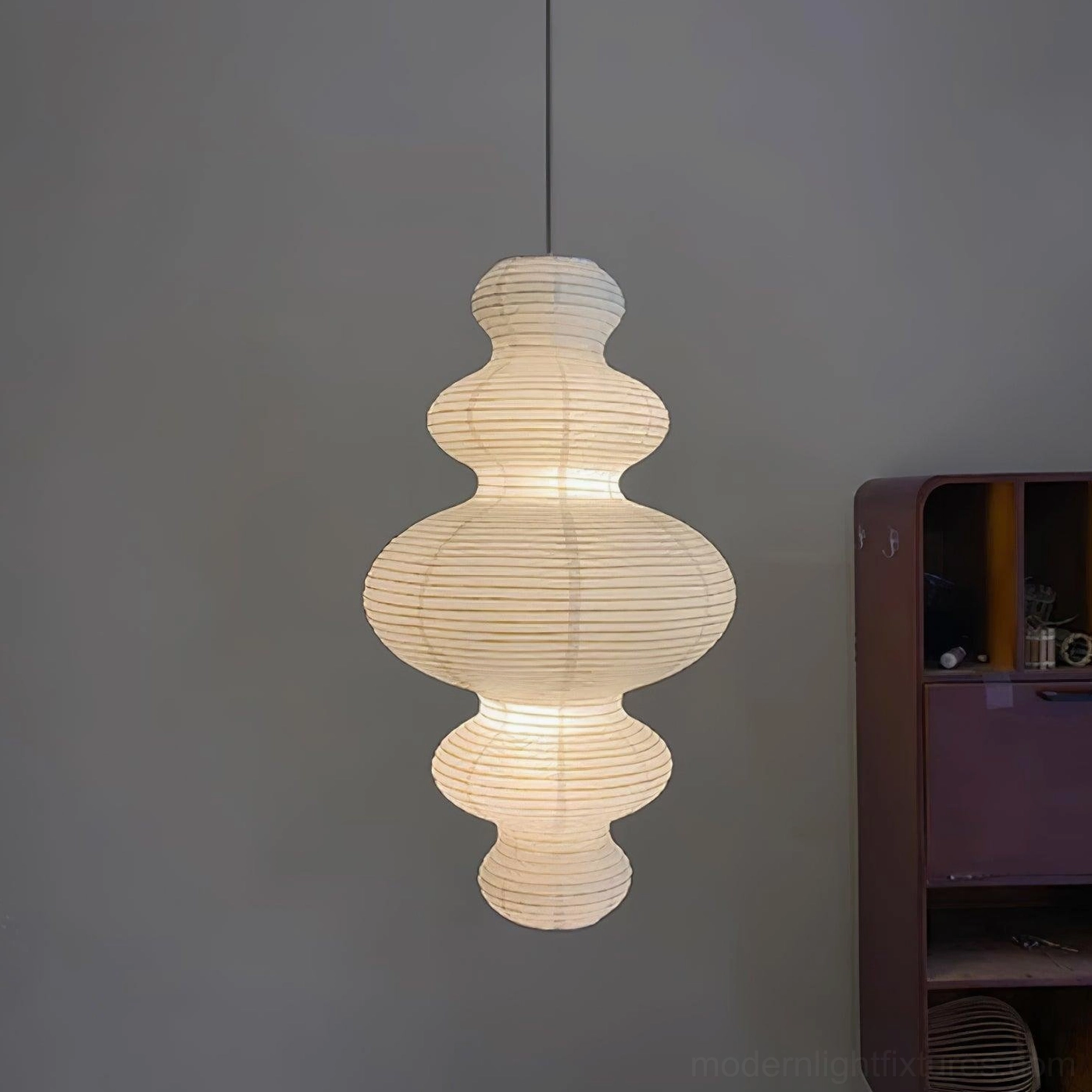 Sculptural white pendant fixture in high ceiling room showing vertical space occupation design