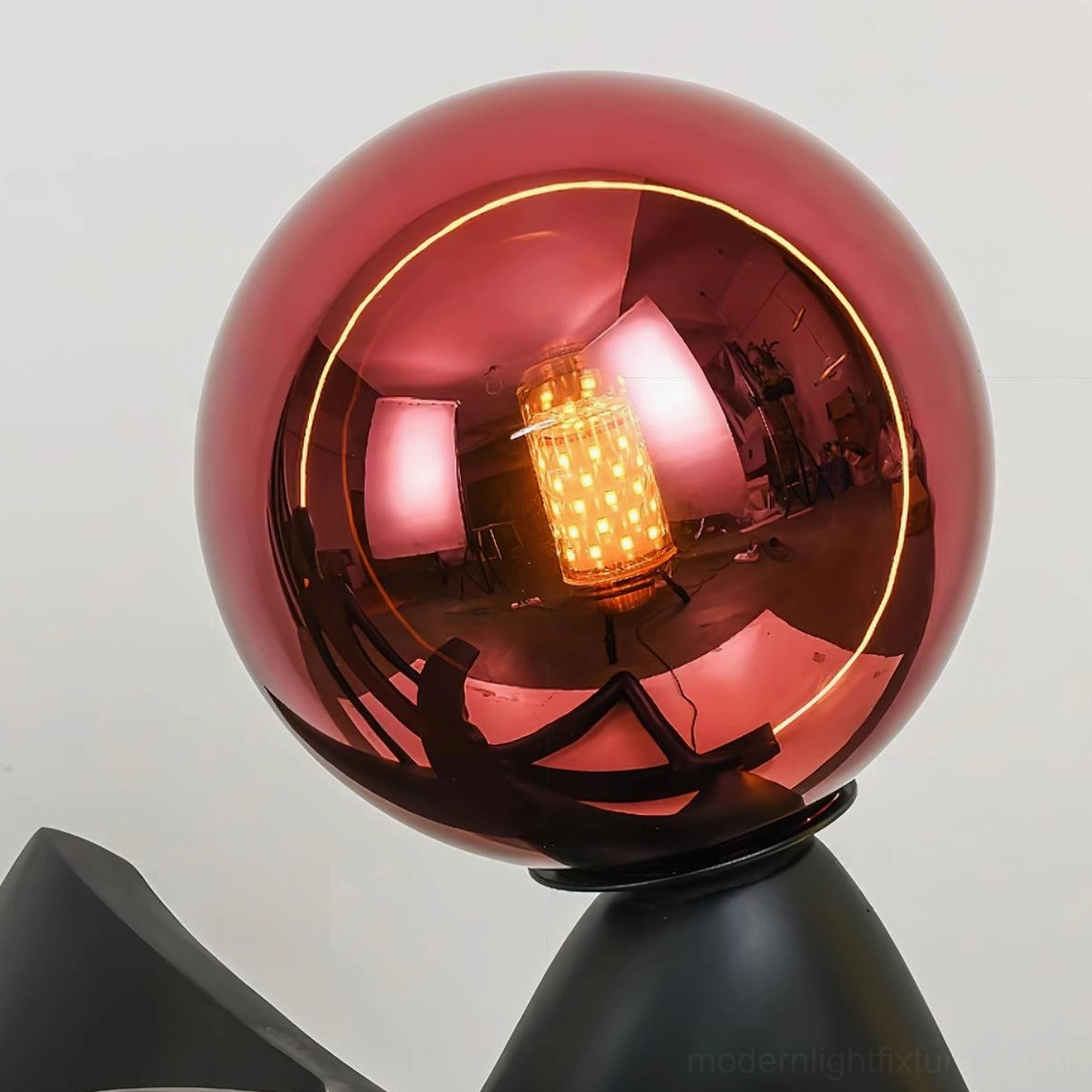 Sculptural reading floor lamp, minimalist black design with red globe, sophisticated modern interior lighting