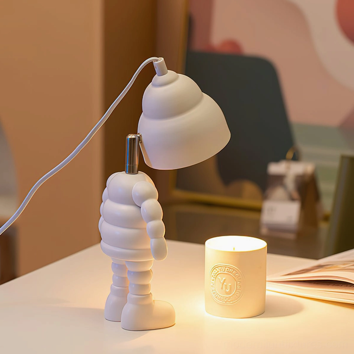 Sculptural robot candle warmer lamp with ceramic resin construction creating soft layered ambient lighting