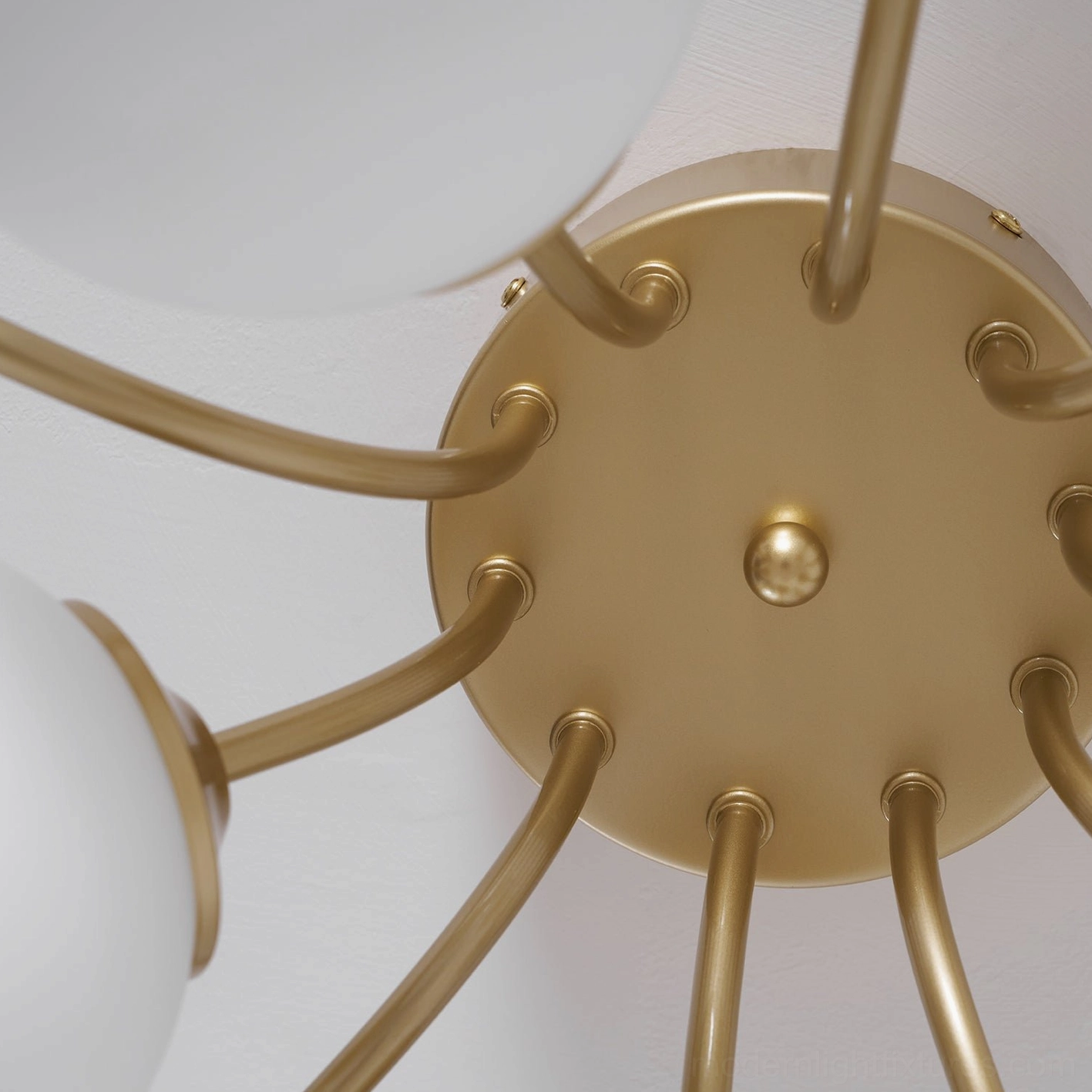 Sputnik ceiling light creating sculptural focal point with starburst brass gold arms and glass shades