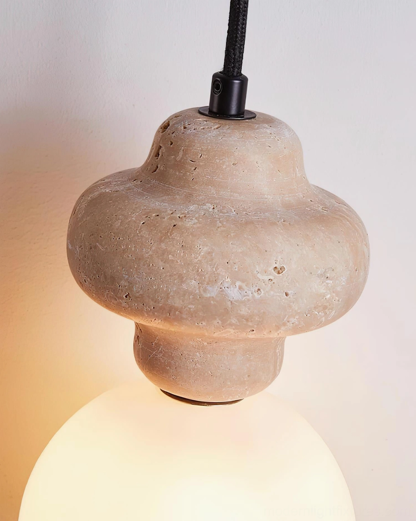 Cenari sculptural pendant light in contemporary interior setting with travertine base and warm frosted glass ambient glow