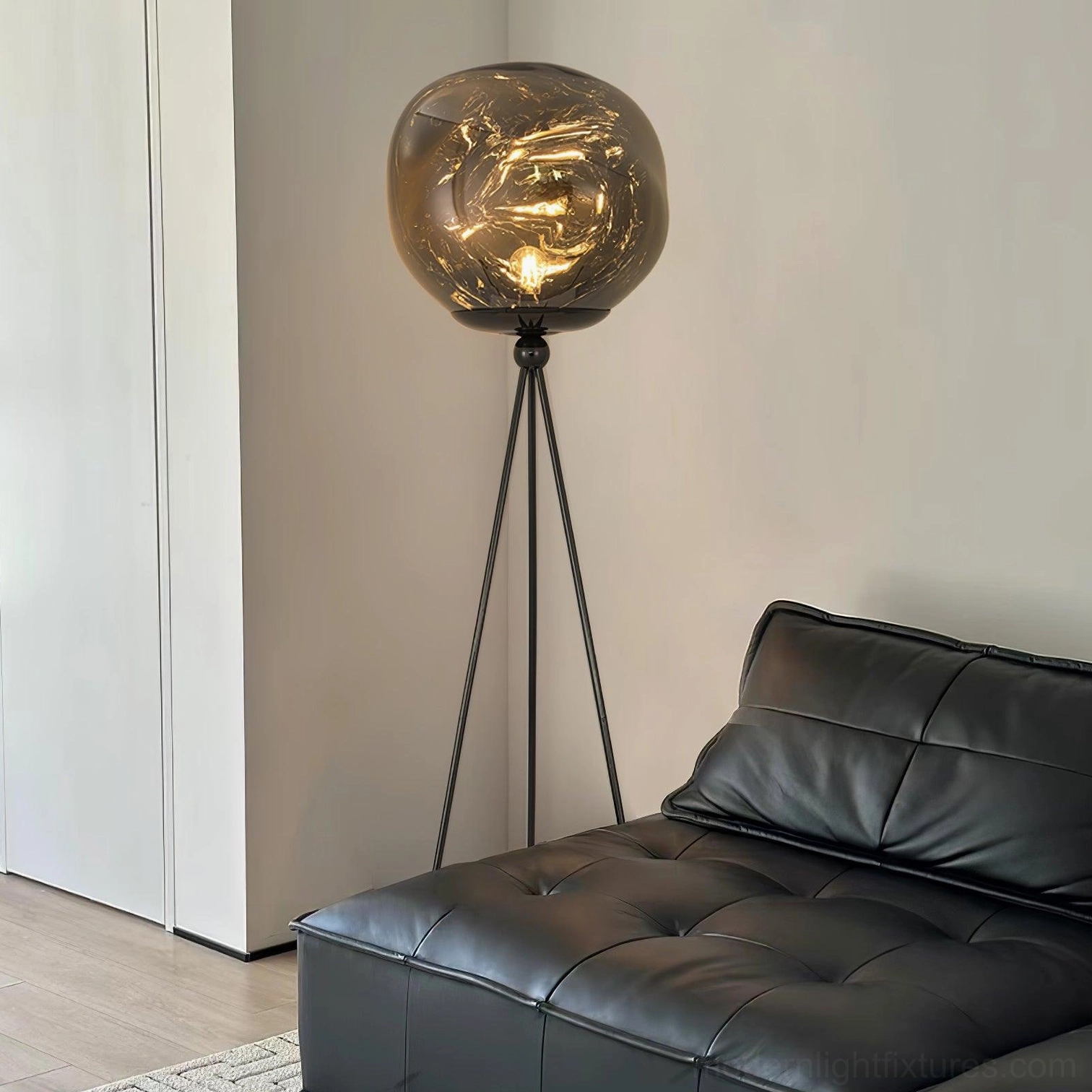 Contemporary tripod floor lamp with sculptural molten glass shade and minimalist metal frame design