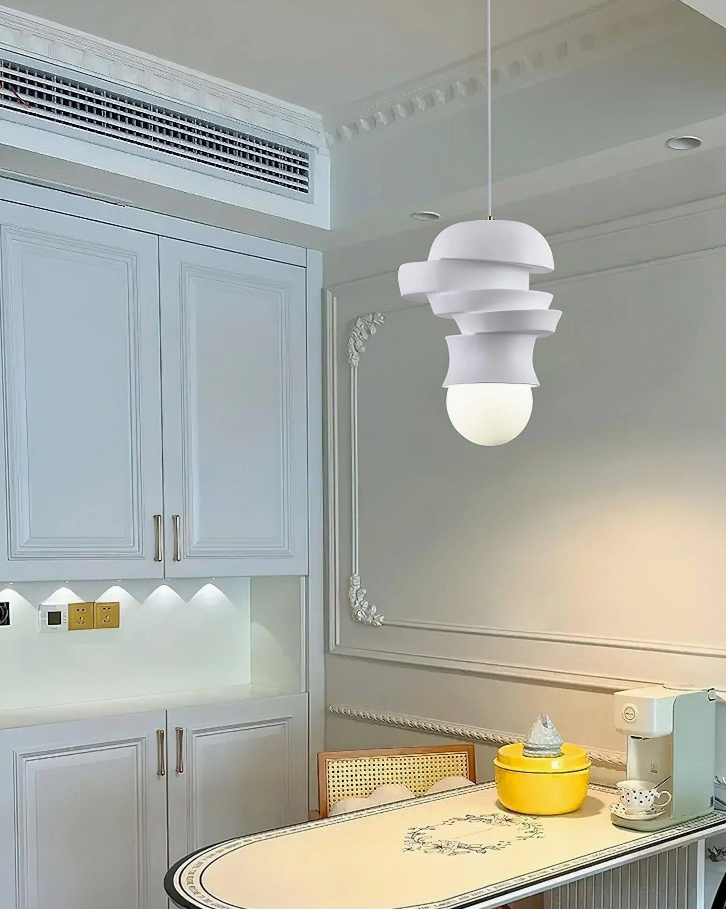 Contemporary pendant lamp with sculptural white stacked discs, modern interior lighting fixture close-up
