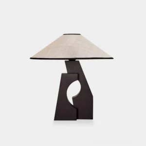 Sculptural minimalist wood table lamp with carved void base and hand-woven beige abaca fiber shade, front studio view