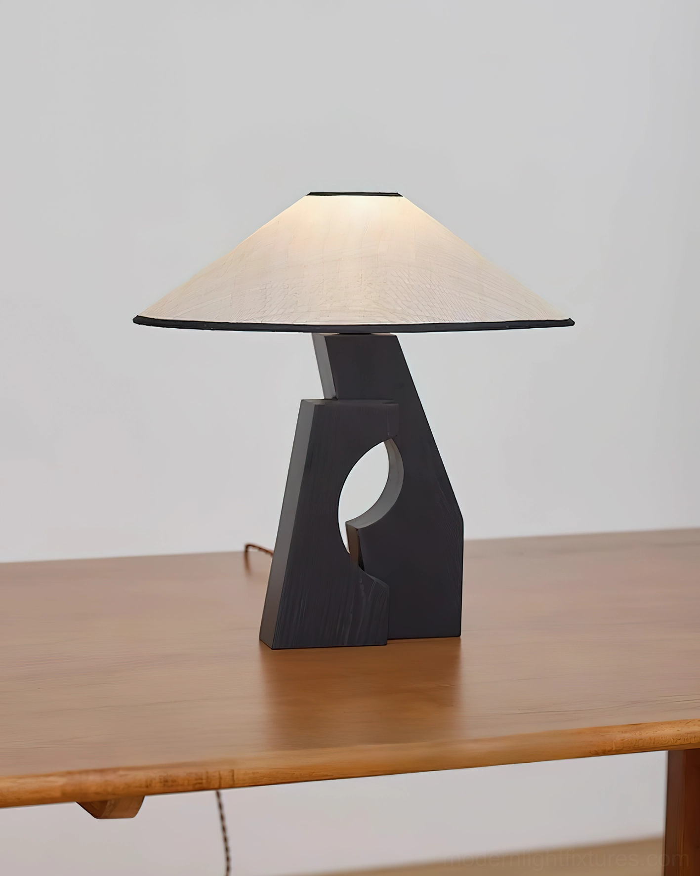 Hand-carved void wood table lamp side view on wooden furniture in minimalist home setting