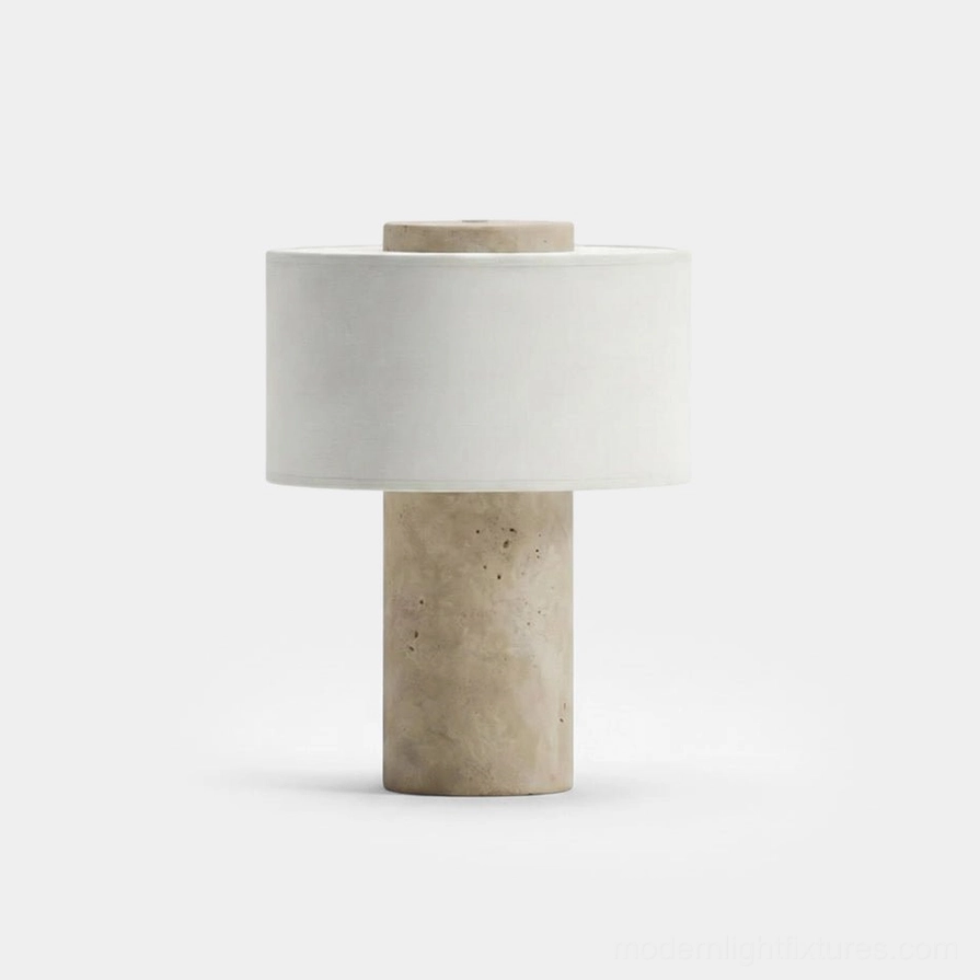 Sediment marble table lamp with beige travertine cylindrical base and off-white fabric shade on pure white studio background