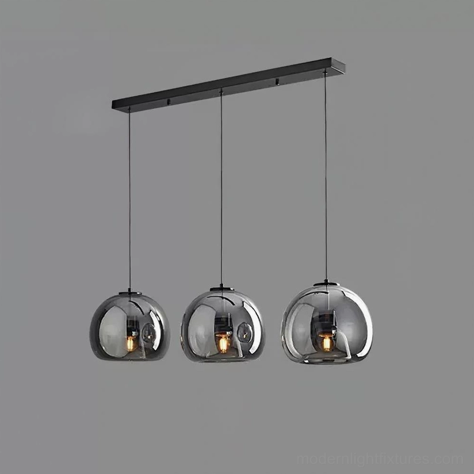 Sedona 3-head linear black pendant light above long dining table contemporary setting
