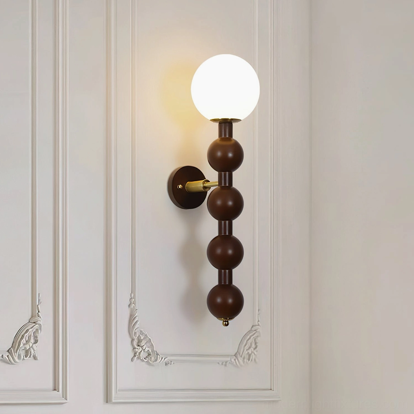 Mid-century modern beaded wall lamp mounted on French carved panel wall with warm glowing light