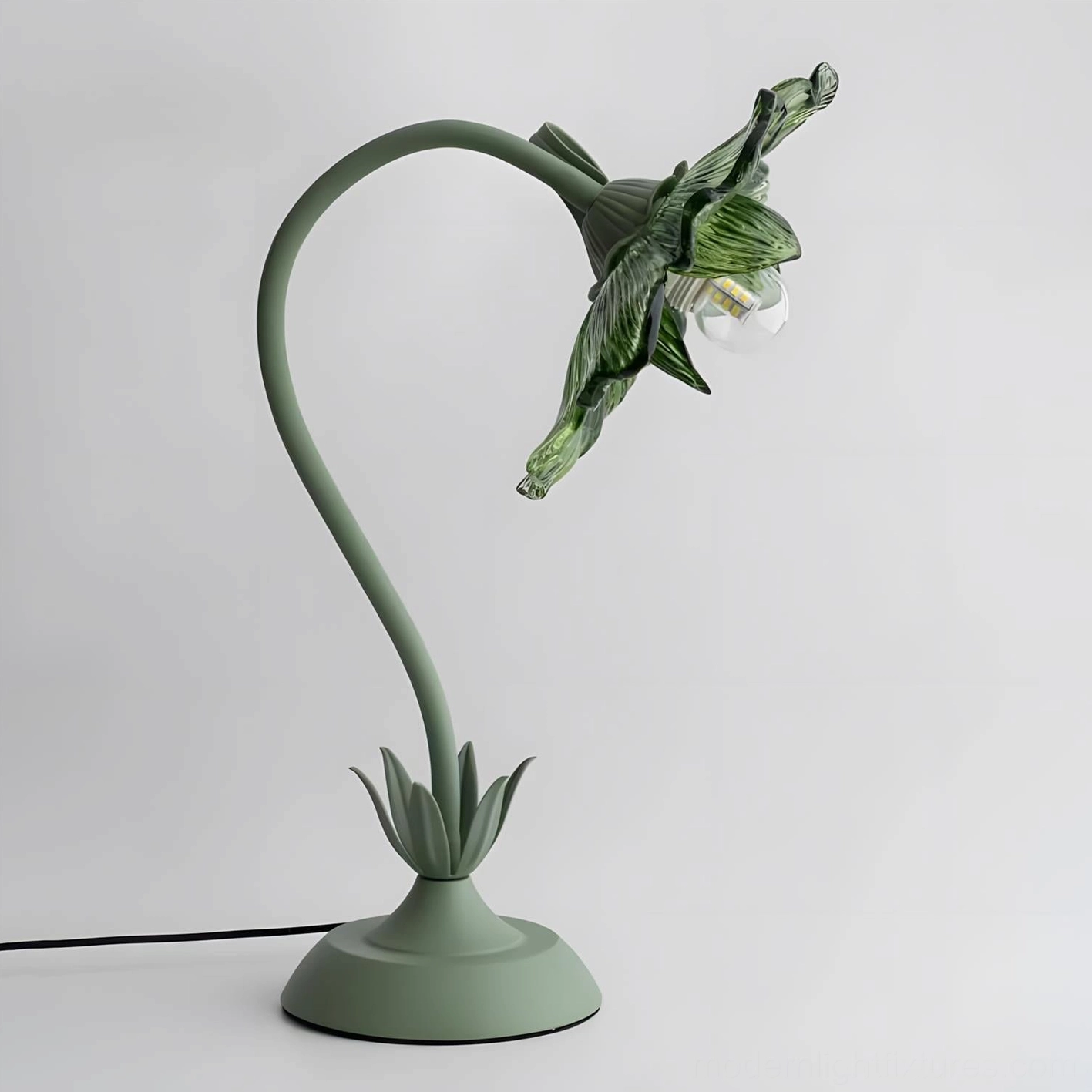 Close-up of green glass flower lamp shade with ribbed translucent texture and warm glowing bulb