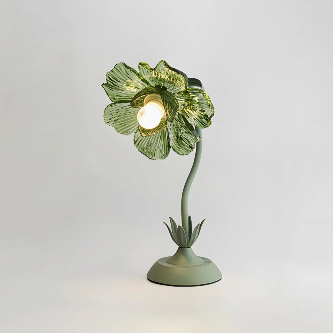 Modern botanical table lamp featuring mint green glass shade and curved metal stem with three-quarter angle view