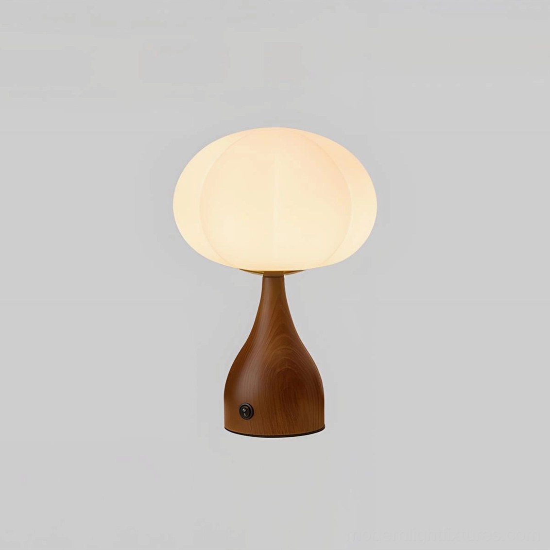 Mid-century inspired table lamp with curved glass shade and warm wood tones in interior setting