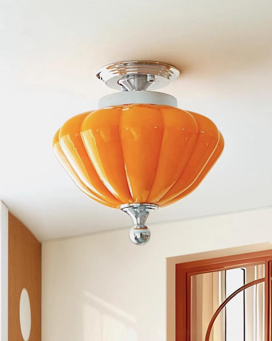Low angle ceiling mounted view of amber orange semi-flush light fixture showing chrome metal hardware and ribbed glass diffuser